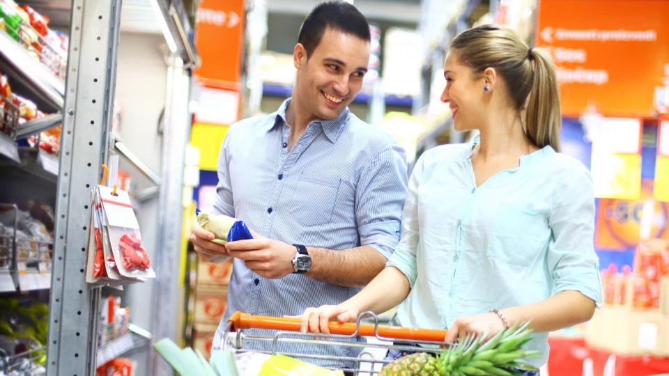 Early 30's couple buying food in supermarket.