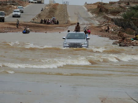 People ride on the back of a truck driving through a flooded road after Cyclone Mekunu hit Socotra Island, Yemen, May 25, 2018. REUTERS/Stringer