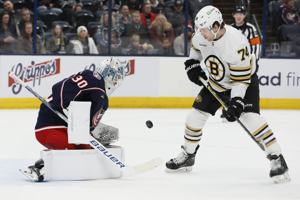 Columbus Blue Jackets' Spencer Martin, left, makes a save against Boston Bruins' Jake DeBrusk (74) during the first period of an NHL hockey game Monday, Nov. 27, 2023, in Columbus, Ohio. (AP Photo/Jay LaPrete)