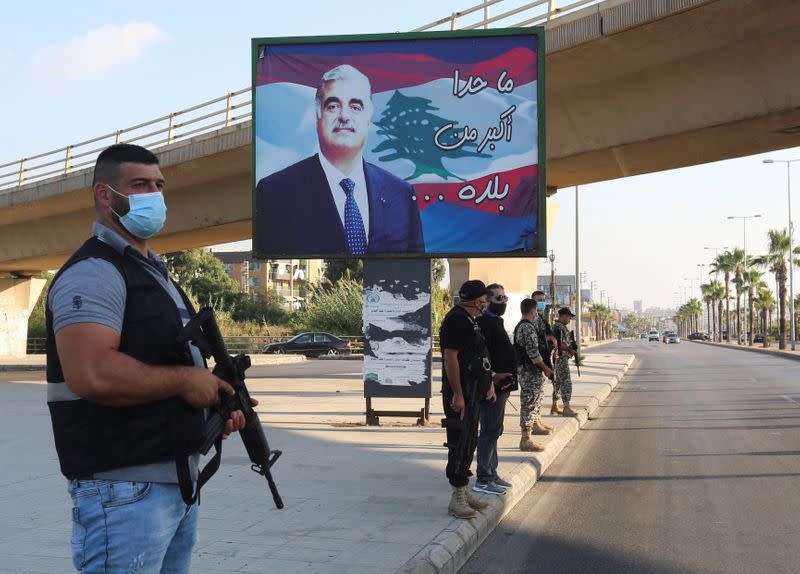 Members of security forces stand guard near a billboard depicting Lebanon's former Prime Minister Rafik al-Hariri, who was killed in a 2005 suicide bombing, in Sidon
