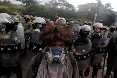 An opposition supporter stands in front of security forces during a protest over a contested presidential election with allegations of electoral fraud in Tegucigalpa, Honduras, December 22, 2017. REUTERS/Jorge Cabrera