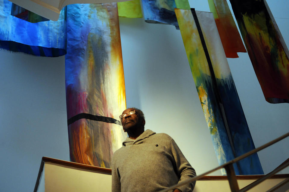 Artist Sam Gilliam oversees the installation of one of his art works, a draped canvas named 