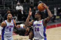 Detroit Pistons center Isaiah Stewart (28) pulls down a rebound next to Sacramento Kings center Richaun Holmes during the first half of an NBA basketball game, Friday, Feb. 26, 2021, in Detroit. (AP Photo/Carlos Osorio)