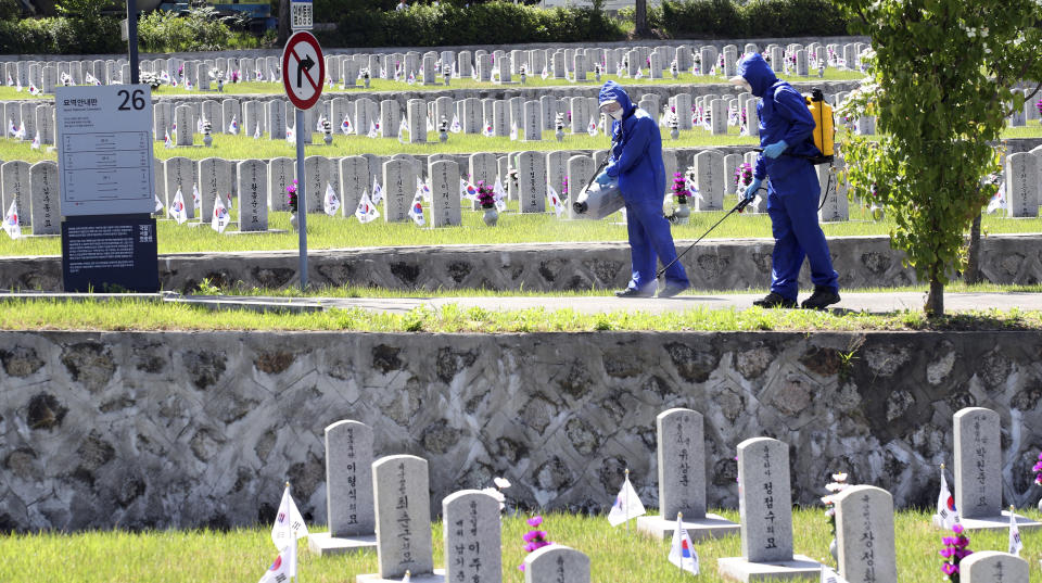 Quarantine officials disinfect as a precaution against the new coronavirus at the National Cemetery in Seoul, South Korea, Monday, June 1, 2020. South Korea is reporting a steady rise in cases around the capital as officials push to require entertainment venues to register their customers with smartphone QR codes so they could be easily located when needed. (Kim In-chul/Yonhap via AP)