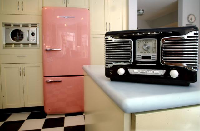 A small kitchen with stainless steel appliances, white cabinets, and a  natural light colored wood counter top Stock Photo - Alamy