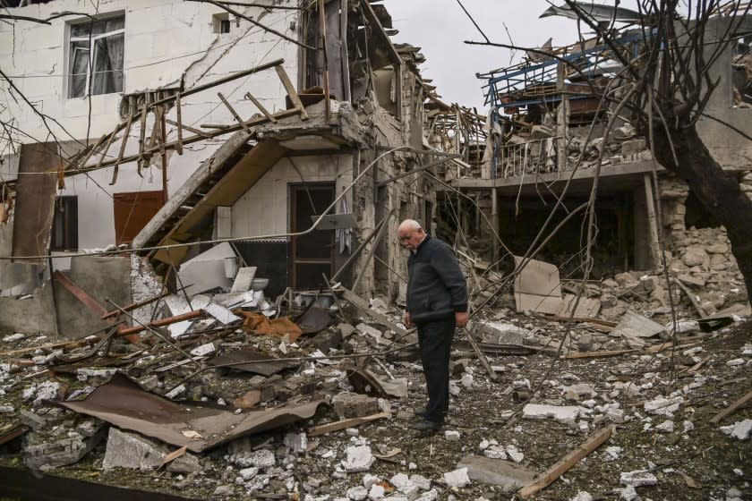 An elderly man stands in front of a destroyed house in the Nagorno-Karabakh region's main city of Stepanakert.