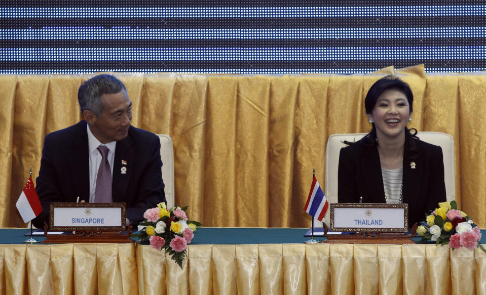 Singapore's Prime Minister Lee Hsien Loong, left, sits next to Thailand's Prime Minister Yingluck Shinawatra during the singing ceremony of adoption of the ASEAN Human Rights Declaration during the 21st Association of Southeast Asian Nations, or ASEAN Summit in Phnom Penh, Cambodia, Sunday, Nov. 18, 2012. (AP Photo/Vincent Thian)