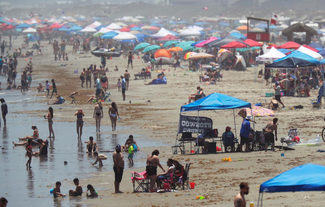 People gather on the beach for the Memorial Day weekend in Port Aransas, Texas on Saturday, May 23, 2020. Beachgoers are being urged to practice social distancing to guard against COVID-19.