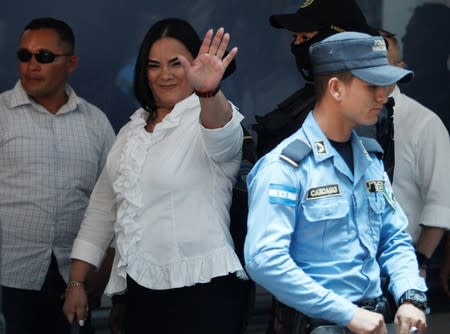 Former first lady Rosa Elena Bonilla de Lobo waves as she arrives at a court hearing to face graft charges, in Tegucigalpa
