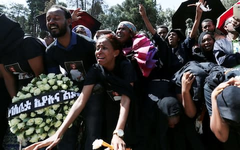 Relatives mourn next to the coffins of Ethiopian passengers and crew members, during a memorial service for the victims of the Ethiopian Airlines Flight ET 302  - Credit: &nbsp;TIKSA NEGERI