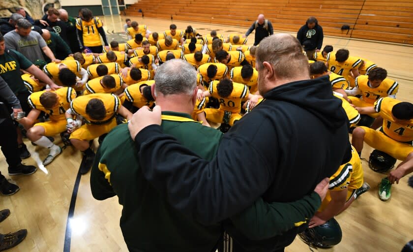PARADISE, CALIFORNIA NOVEMBER 15, 2019-Paradise High School head coach Rick Prinz and assistant coach Andy Hopper lead a prayer before a playoff game against Live Oak. (Wally Skalij/Los Angerles Times)