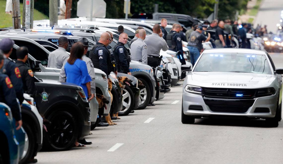 K9 officers watch as procession for slain Wake County Sheriffs Deputy Ned Byrd drives down Glenwood Avenue past the Five Points neighborhood in Raleigh, N.C., Friday, August 19, 2022.