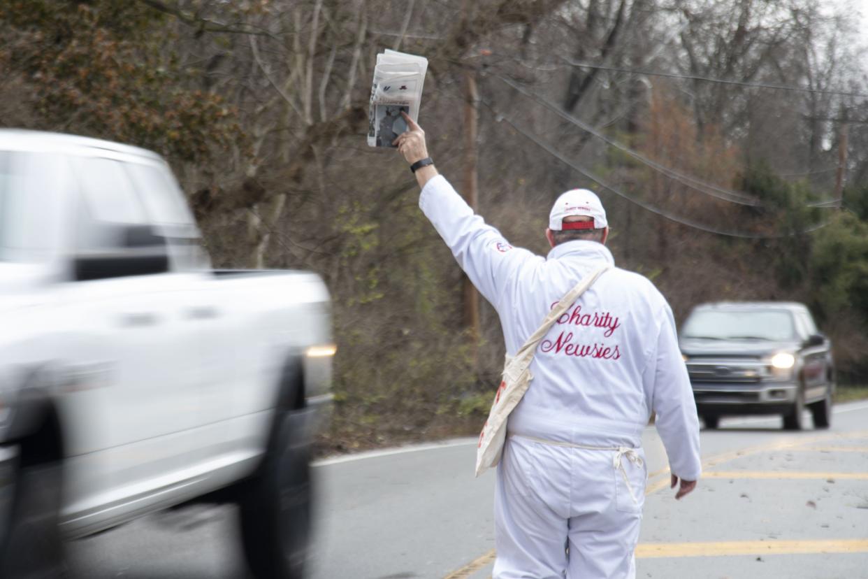 A man sells papers with the Charity Newsies in 2021 at the intersection of Olentangy River Road and Clubview Boulevard.