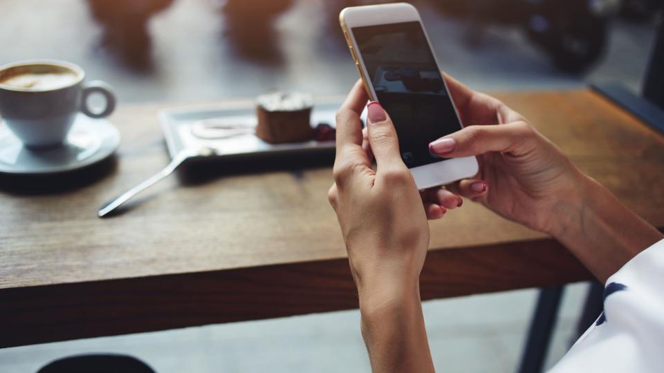 woman holding phone using camera