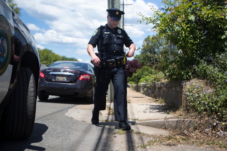 New Castle Police Officer Joseph Shanahan walks back to his vehicle after pulling over a woman for speeding while on patrol Friday, May 14, 2021. 