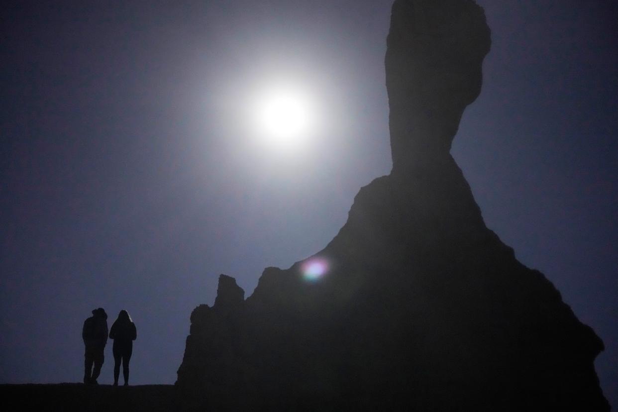 People watch the start of the eclipse over Bryce Canyon National Park, Utah, during a rare "ring of fire" eclipse of the sun Saturday, Oct. 14, 2023.