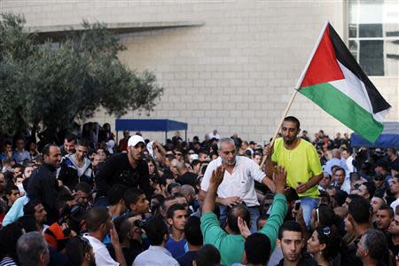 An Israeli Arab man (R) holds a Palestinian flag as he is carried by supporters after his sentencing during a protest outside the district court in the northern city of Haifa November 28, 2013. REUTERS/Nir Elias