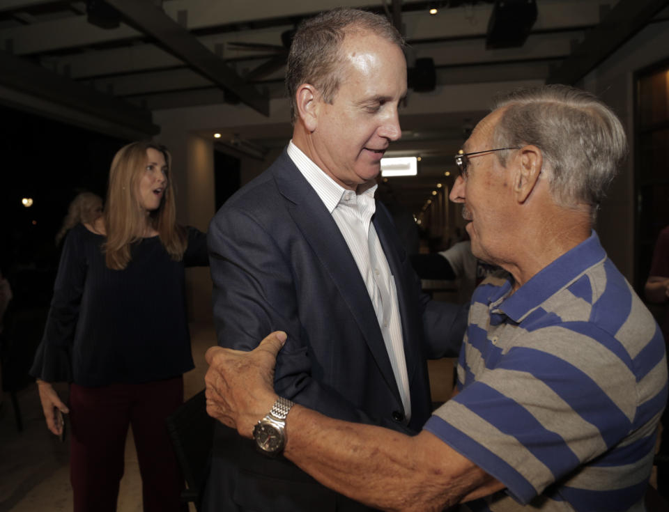 Congressman Mario Diaz-Balart, center, is greeted by a supporter during a victory party at the Flamingo Terrace at Hialeah Park, Tuesday, Nov. 6, 2018, in Hialeah, Fla. (Jose A. Iglesias/Miami Herald via AP)