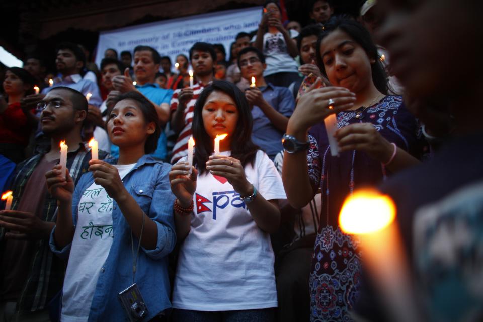 Nepalese youth light candles in memory of the 16 Nepalese Sherpa guides killed in avalanche on Mount Everest in Katmandu, Nepal, Wednesday, April 30, 2014. The April 18 avalanche was the deadliest disaster on the world's highest mountain. (AP Photo/Niranjan Shrestha)