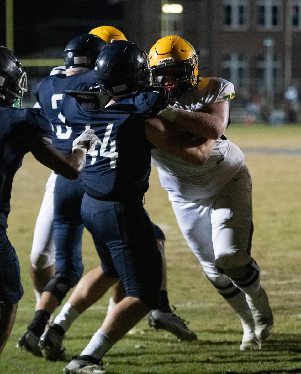 Ryland Bragg (72) engages the Braves defensive line as the Crusaders score a touchdown to take a 41-7 lead during the Catholic vs Walton high school playoff football game at Walton HIgh School in DeFuniak Springs on Friday, Nov. 17, 2023.