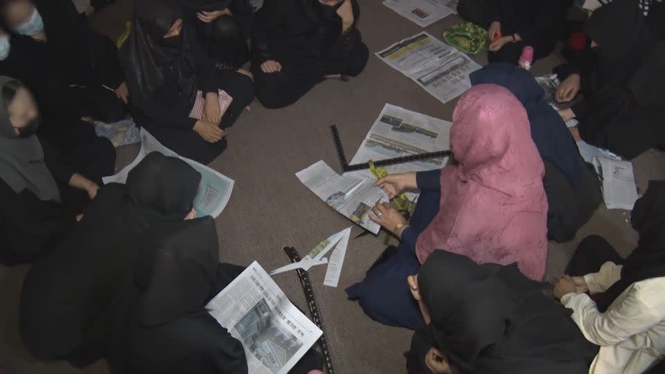 Girls are taught tailoring techniques using newspapers at the hidden school in Afghanistan. - CNN