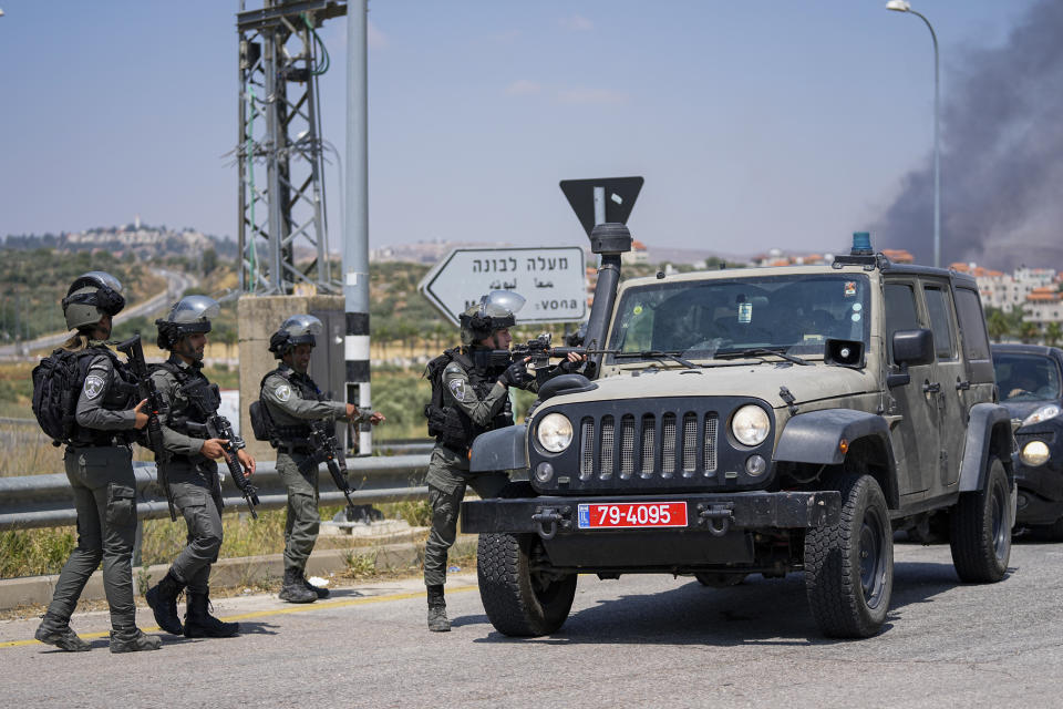 Israeli border police officers are seen on a main road next to the West Bank town of Turmus Ayya, Wednesday, June 21, 2023. The Israeli army has beefed up its forces across the occupied West Bank and prepared to demolish the homes of two Palestinian gunmen who killed four Israelis in one of the worst attacks in the past year of violence. (AP Photo/Ohad Zwigenberg)