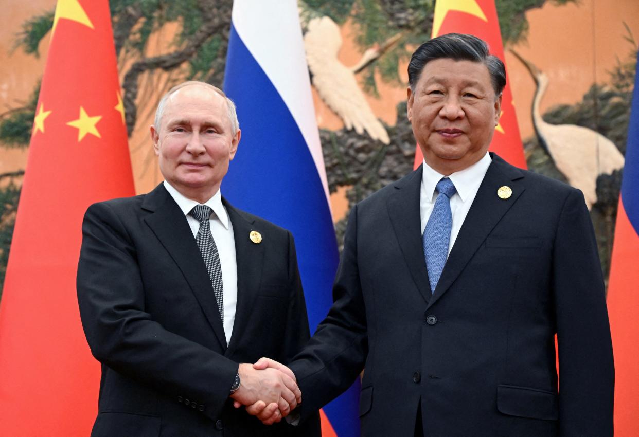 Vladimir Putin shakes hands with Chinese President Xi Jinping during a meeting in Beijing (via REUTERS)