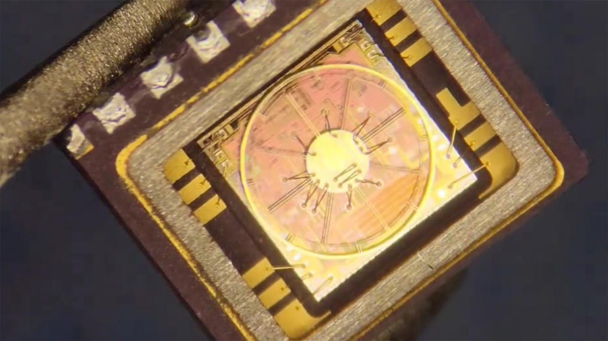  A screengrab of a video showing someone removing the casing from a semiconductor under a microscope. 