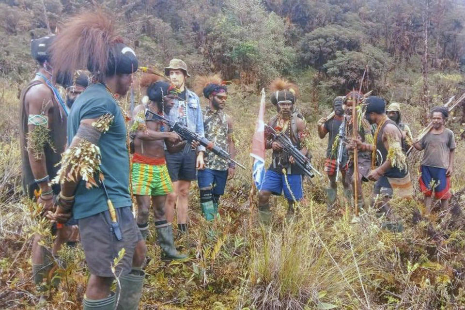 In this undated photo released by West Papua Liberation Army, the armed wing of the Free Papua Movement, Papuan separatist rebels pose for a photo with a man they said is New Zealander pilot Phillip Mark Mehrtens, third right, who they took hostage last week, at an undisclosed location in Papua province, Indonesia. Mehrtens, a pilot for Indonesian aviation company Susi Air, was abducted by the independence fighters who stormed his single-engine plane shortly after it landed on a small runway in Paro in remote Nduga district. (West Papua Liberation Army via AP)