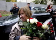 Belarussian author Svetlana Alexievich holds flowers as she arrives to attend a news conference in Minsk, Belarus, October 8, 2015. REUTERS/Vasily Fedosenko