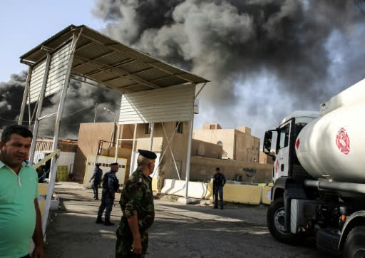 Iraqi federal policemen stand outside the country's biggest ballot warehouse hit by a fire and where votes for the eastern Baghdad district were stored on June 10, 2018