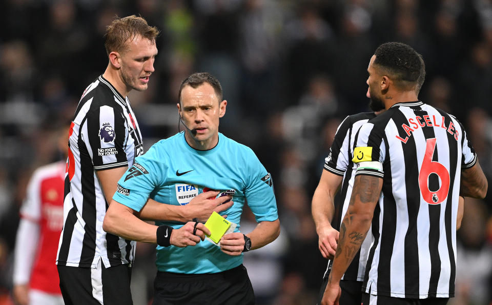 NEWCASTLE UPON TYNE, ENGLAND - NOVEMBER 04: Referee, Stuart Attwell is confronted by Dan Burn and Jamaal Lascelles of Newcastle United during the Premier League match between Newcastle United and Arsenal FC at St. James Park on November 04, 2023 in Newcastle upon Tyne, England. (Photo by Stu Forster/Getty Images)