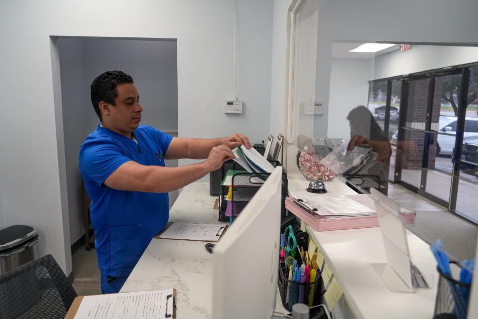 Frank Gonzalez, a medical assistant at Clinica Hispana Rubymed, grabs forms for patients to fill out at the Round Rock location Feb. 9. The new clinic is meant to help meet the health care needs of uninsured people in the Hispanic community.