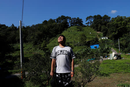 Chen Hong-zhi, 26, who suffers from short-term memory loss, reacts after removing weeds at his farmland, in Hsinchu, Taiwan, July 31, 2018. REUTERS/Tyrone Siu