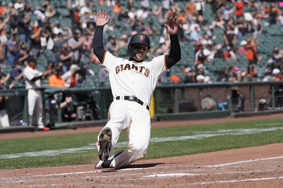 San Francisco Giants' Tommy La Stella slides home to score against the Colorado Rockies during the third inning of a baseball game in San Francisco, Saturday, April 10, 2021. (AP Photo/Jeff Chiu)