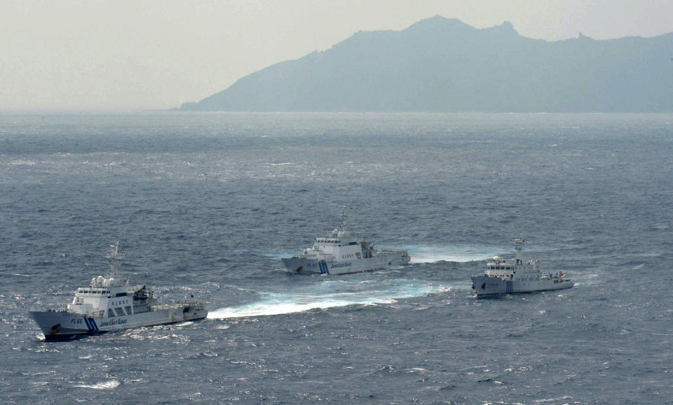 Japan Coast Guard vessels sail along with Chinese surveillance ship Haijian No. 66, right, near disputed islands called Senkaku in Japan and Diaoyu in China, seen in background, in the East China Sea, on Monday, Sept. 24, 2012. (AP Photo/Kyodo News) JAPAN OUT, MANDATORY CREDIT, NO LICENSING IN CHINA, HONG KONG, JAPAN, SOUTH KOREA AND FRANCE
