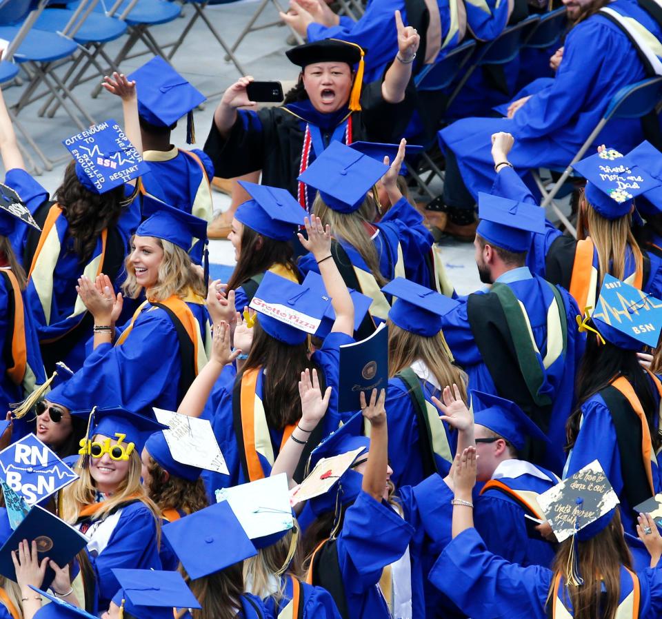 A file photo of University of Delaware nursing students cheering as their school is recognized at graduation.