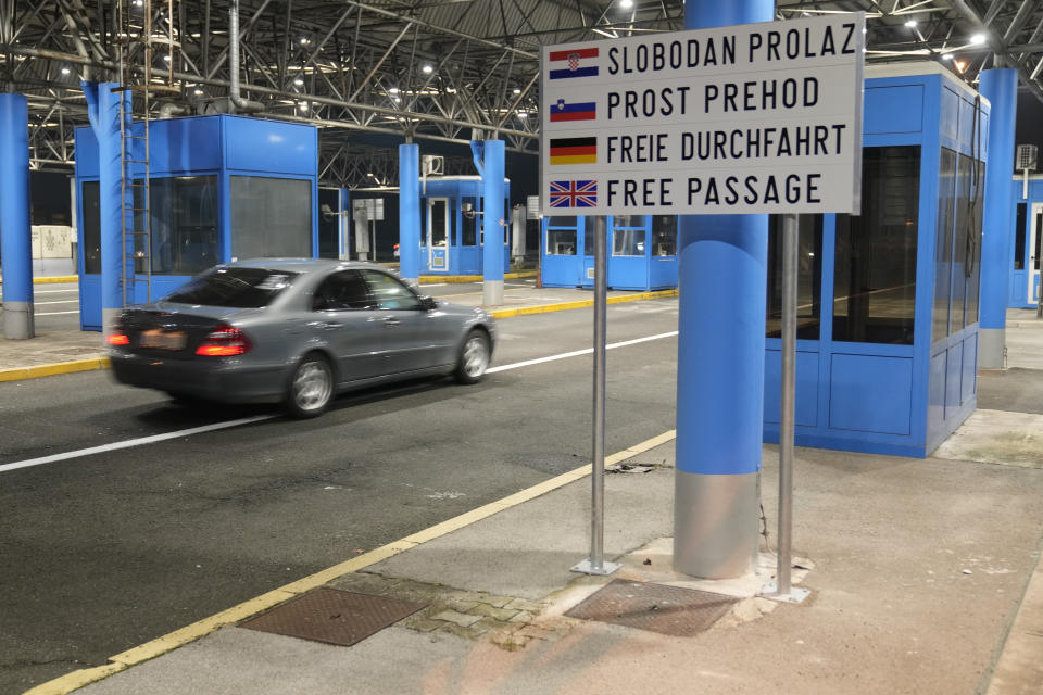 A motorist drives without interruption at the Bregana border crossing between Croatia and Slovenia, early Sunday, Jan. 1, 2023. More than nine years after Croatia became the European Union's newest member, it is switching to the EU's common currency, the euro, and joining Europe's passport-free travel Schengen area. (AP Photo/Darko Bandic)