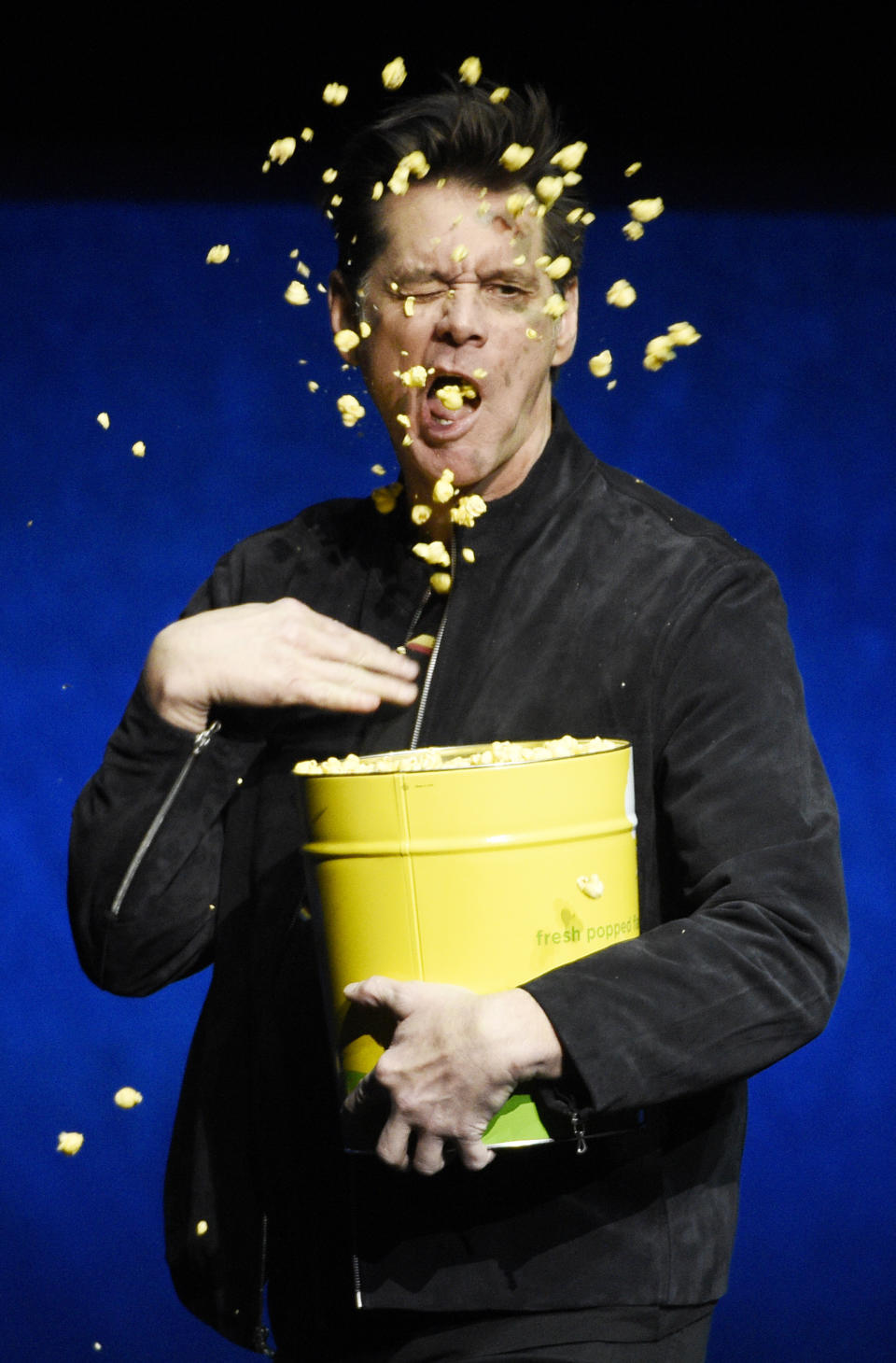 Jim Carrey, a cast member in the upcoming film "Sonic the Hedgehog," throws popcorn onto his face during the Paramount Pictures presentation at CinemaCon 2019 in Las Vegas on April 4, 2019. (Photo by Chris Pizzello/Invision/AP)