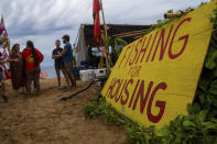 Lahaina Strong members speak together on Friday, Dec. 1, 2023, in Lahaina, Hawaii. Lahaina Strong has set up a "Fish-in" to protest living accommodations for those displaced by the Aug. 8, 2023 wildfire, the deadliest U.S. wildfire in more than a century. More than four months after the fire, tensions are growing between those who want to welcome tourists back to provide jobs and those who feel the town isn't ready for a return to tourism. (AP Photo/Ty O'Neil)