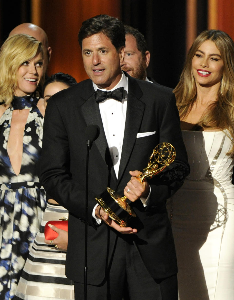 FILE - This Aug. 25, 2014 file photo shows show creator Steven Levitan, center, accepting the award for outstanding comedy series for "Modern Family" at the 66th Annual Primetime Emmy Awards in Los Angeles. Looking are cast members Julie Bowen, left, and Sofía Vergara. The popular comedy series, which earned five best comedy Emmy Awards, ends its 11-season run with a two-hour finale on Wednesday. (Photo by Chris Pizzello/Invision/AP, File)