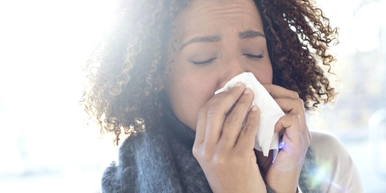 Woman blowing nose on tissue