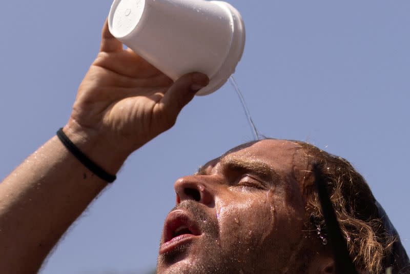FILE PHOTO: Man pours water atop head during heat wave in Houston