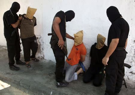 Hamas militants grab Palestinians suspected of collaborating with Israel, before executing them in Gaza City August 22, 2014. REUTERS/Stringer