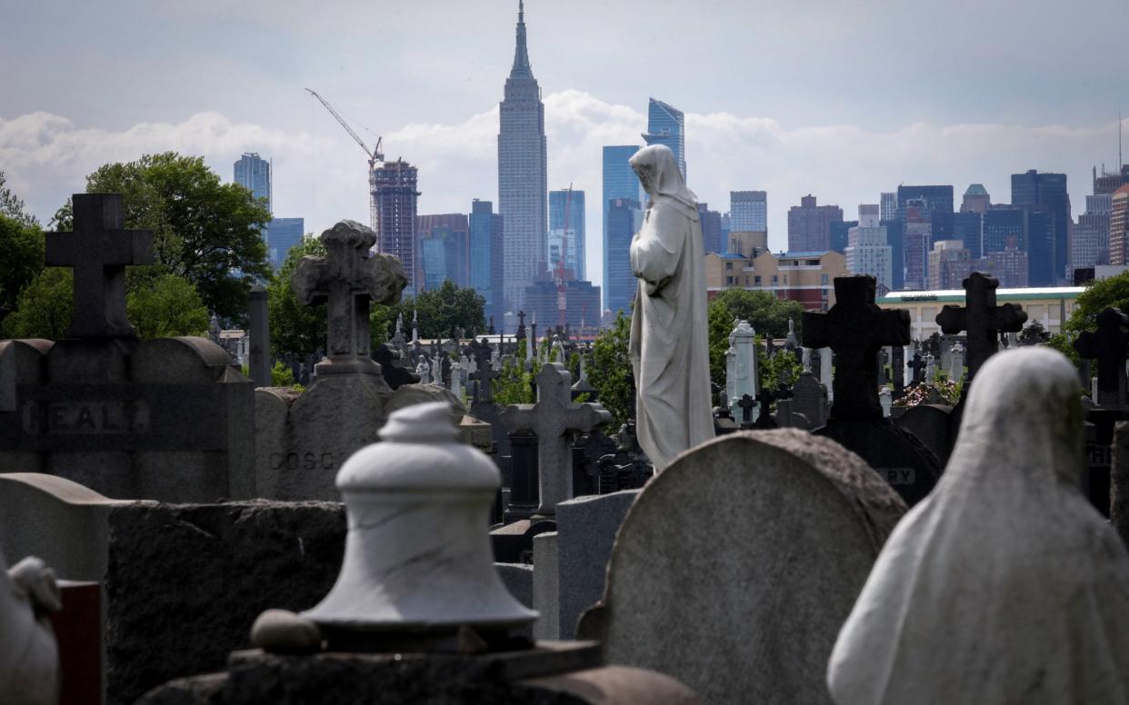 Manhattan Skyline beyond graves in Calvary Cemetery during outbreak of the coronavirus disease - Reuters