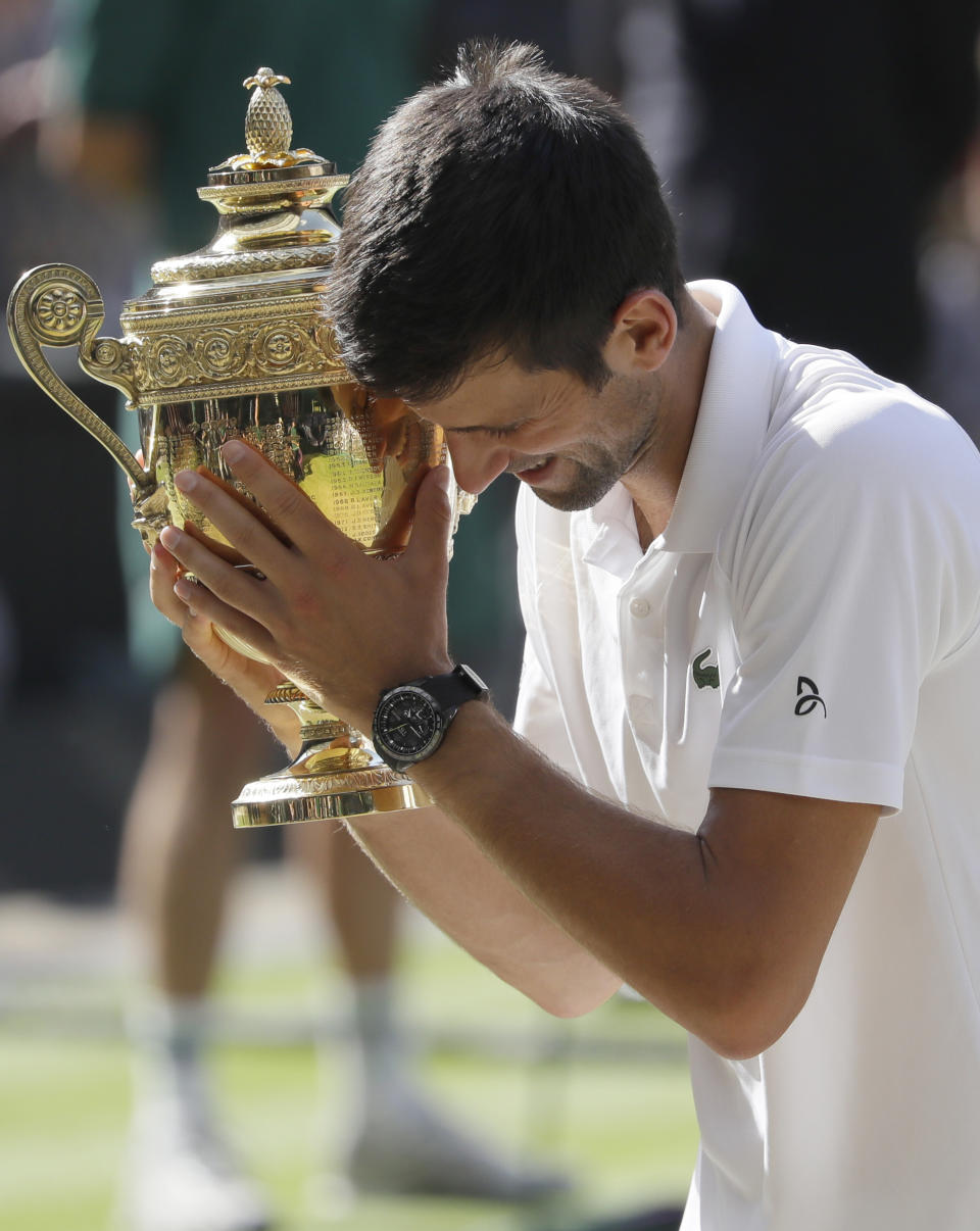 FILE - In this July 15, 2018, file photo, Serbia's Novak Djokovic holds the trophy after winning the men's singles final match against Kevin Anderson of South Africa, at the Wimbledon Tennis Championships in London. (AP Photo/Kirsty Wigglesworth, File)