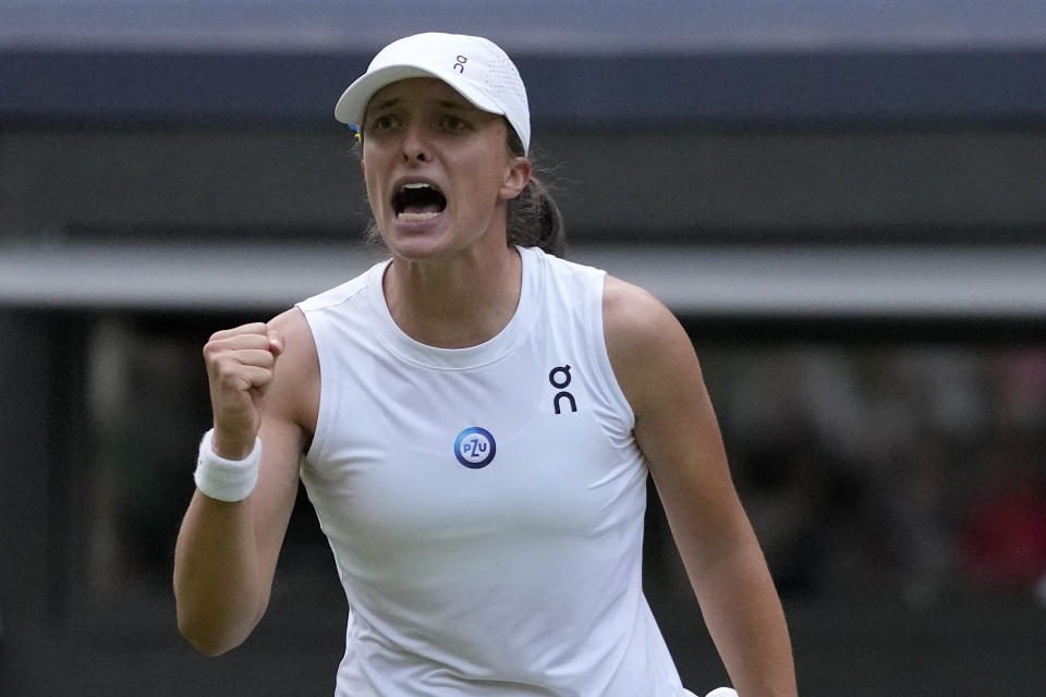 Poland's Iga Swiatek celebrates after beating Switzerland's Belinda Bencic in a women???s singles match on day seven of the Wimbledon tennis championships in London, Sunday, July 9, 2023. (AP Photo/Kirsty Wigglesworth)