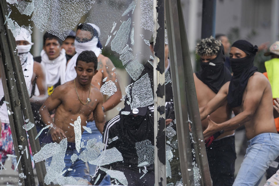 Manifestantes destrozan un panel de publicidad en las protestas contra los resultados de las elecciones que dieron por ganador a Nicolás Maduro, el día después de las votaciones en Caracas, Venezuela, el lunes 29 de julio de 2024. (AP Foto/Matías Delacroix)