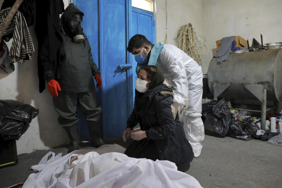 A woman mourns over the body of her mother Parvin Enayati, 50, who died from COVID-19 at a cemetery in the Khajoo Kola village on the outskirts of the city of Ghaemshahr, in northern Iran, Thursday, Dec. 17, 2020. (AP Photo/Ebrahim Noroozi)