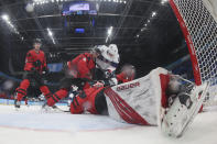 Canada goalkeeper Eddie Pasquale stretches out on the ice as Canada's Mark Barberio (44) and United States' Nick Abruzzese (16) fight for the puck during a preliminary round men's hockey game at the 2022 Winter Olympics, Saturday, Feb. 12, 2022, in Beijing. (Bruce Bennett/Pool Photo via AP)